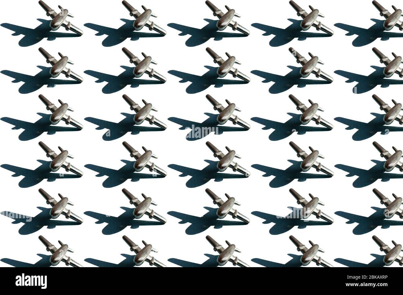 Dreißig Metallfiguren von kleinen silberfarbenen Flugzeugen mit Schatten auf dem weißen Hintergrund. Konzeptionelle geometrische Kunst trendy Muster. Luftfahrt Stockfoto