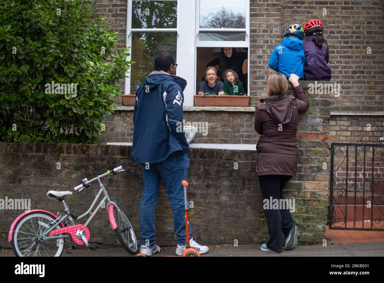 **Elternerlaubnis gewährt** zwei Familien unterhalten sich außerhalb eines Hauses in Hampstead, Nordlondon, während Großbritannien weiterhin in der Blockierung ist, um die Ausbreitung des Coronavirus einzudämmen. Stockfoto
