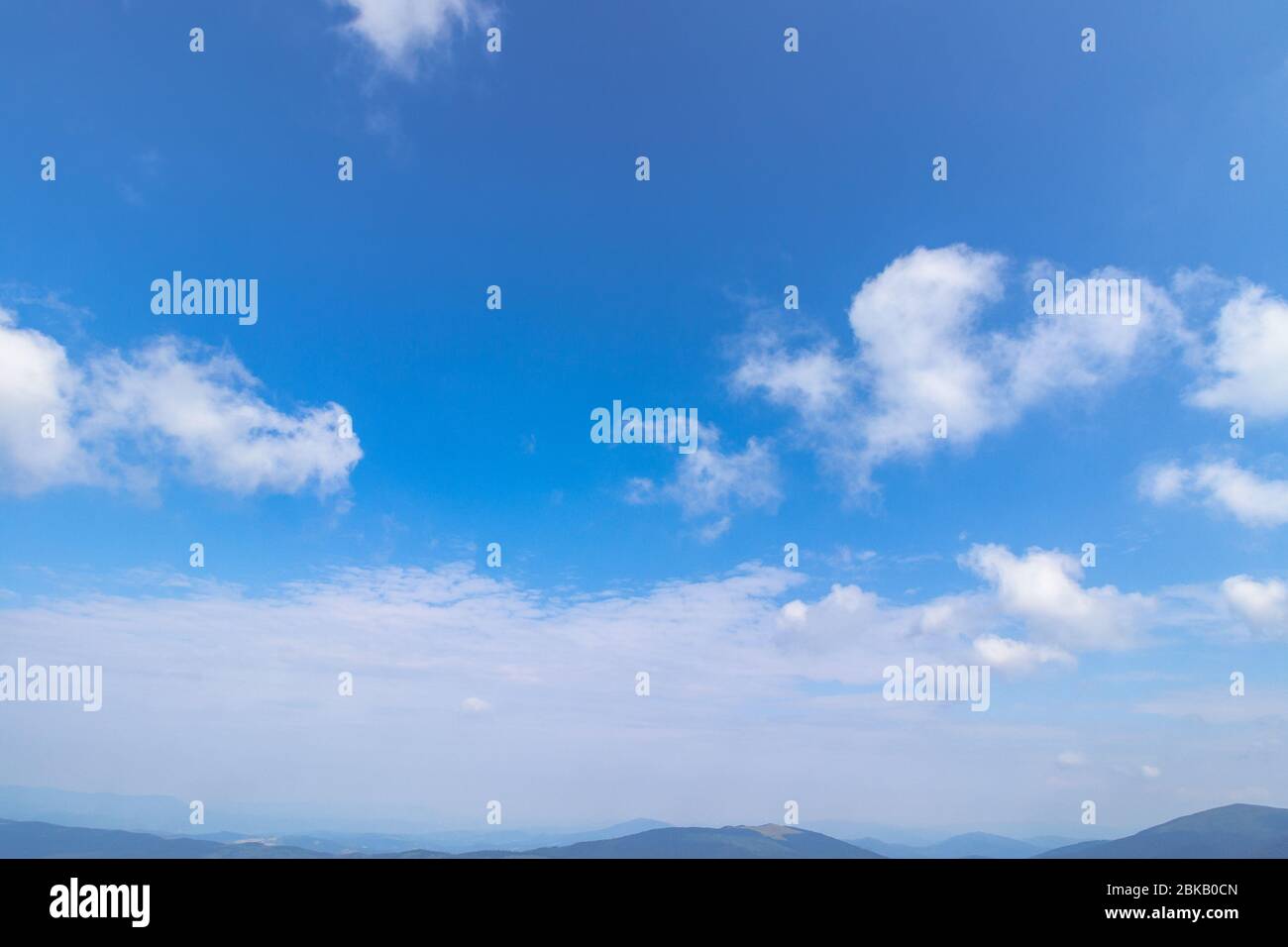 Sonnende Wolkenlandschaft an einem Sommertag. Schöne sonnige Wettervorhersage. Dynamische Wolkenbildung am blauen Himmel Stockfoto