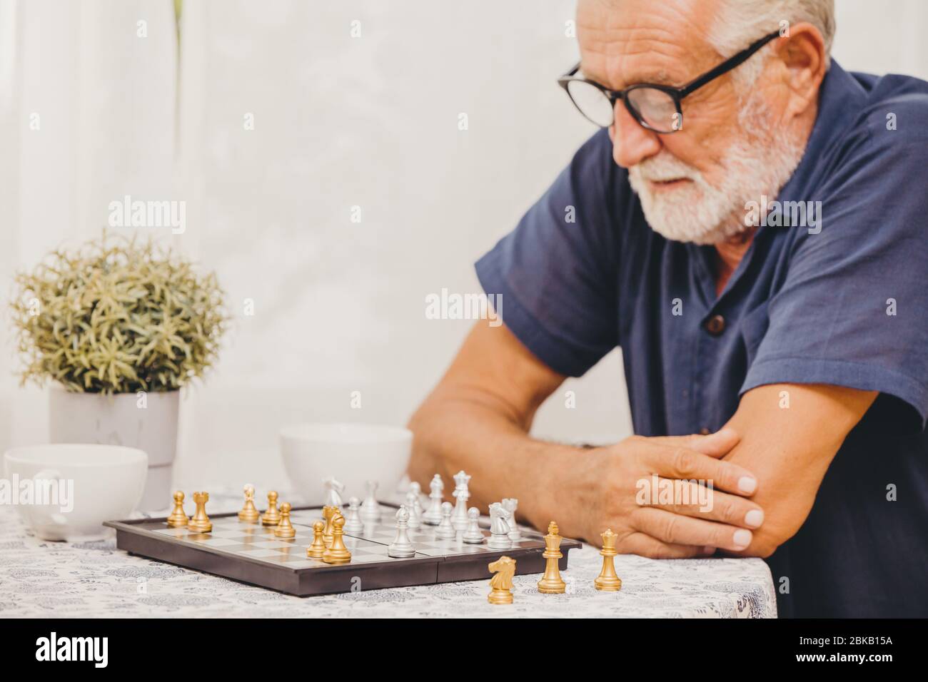 Smart Elder spielen Schach Spiel zu Hause für die Ausbildung von Gehirn, Gedächtnis und Denken glücklich lächelnde selektiven Fokus im Schach. Stockfoto