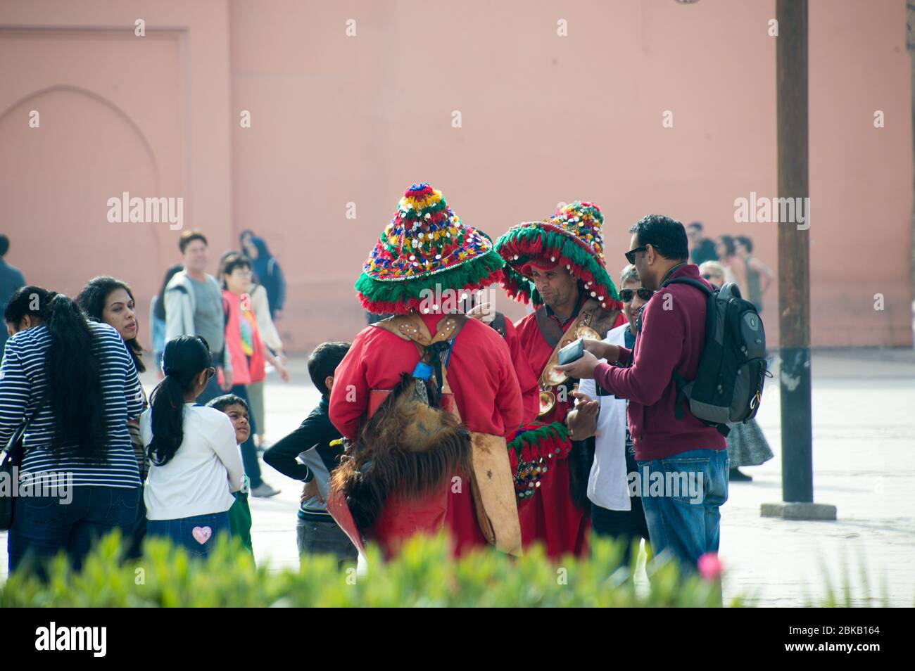 Touristen posieren mit traditionellen Wasserverkäufern in der Stadt Marrakesch (Marrakesch), Marokko, Nordafrika Stockfoto