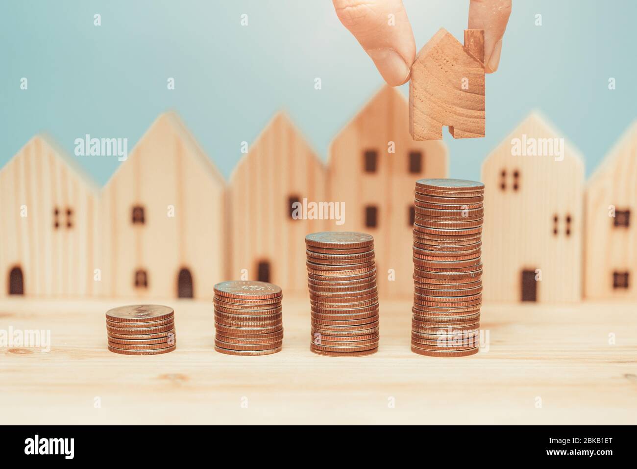 Münzstapel mit Holzhaus Modell für das Sparen von Geld, um ein neues Haus Konzept zu kaufen. Stockfoto