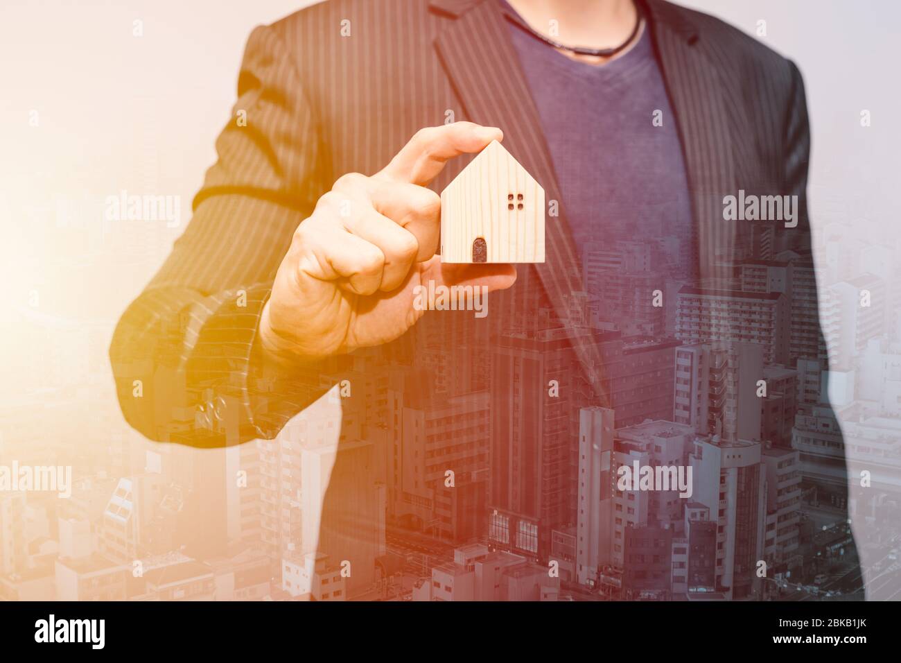 Geschäftsmann hält Home Overlay mit Stadthaus für Hausbesitzer Hypothekendarlehen und finanzielle für das Leben Konzept. Stockfoto