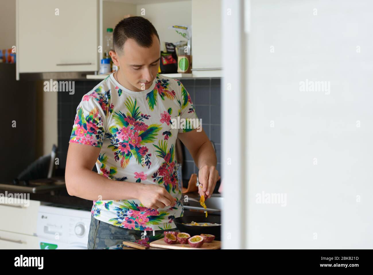 Ein schöner Mann, der zu Hause in der Küche Essen zubereitet Stockfoto