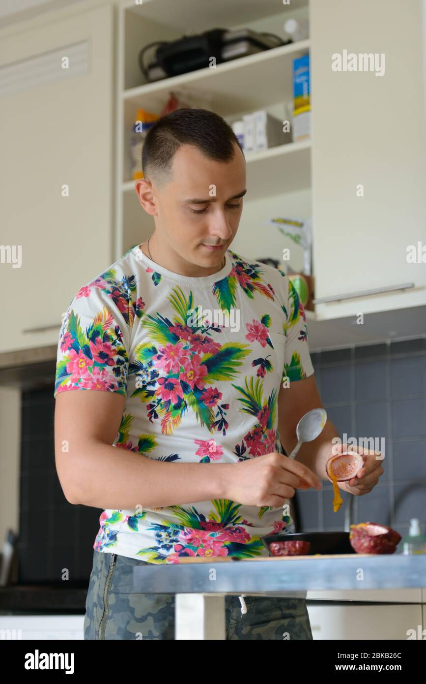Ein schöner Mann, der zu Hause in der Küche Essen zubereitet Stockfoto