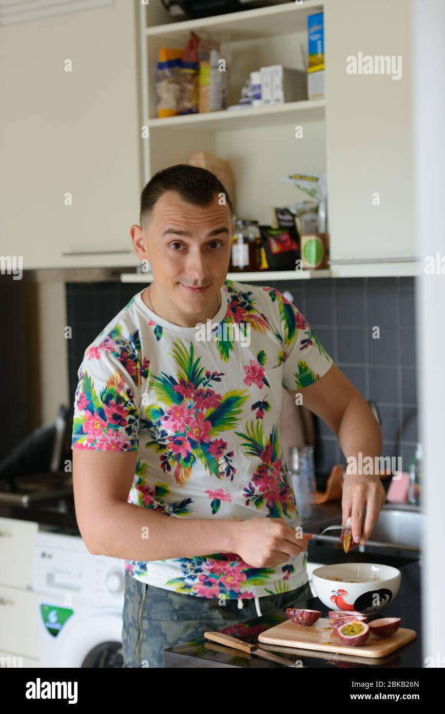 Ein schöner Mann, der zu Hause in der Küche Essen zubereitet Stockfoto