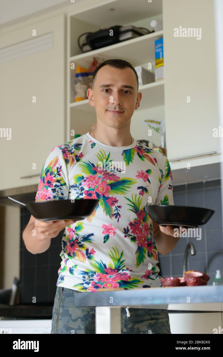 Ein schöner Mann, der zu Hause in der Küche Essen zubereitet Stockfoto