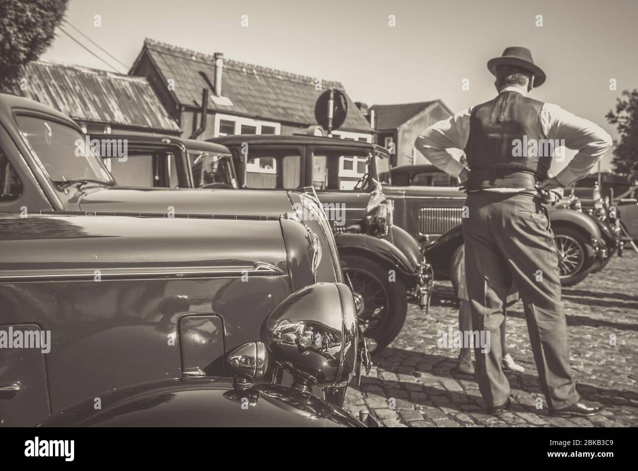 Monochrome Rückansicht von 1940 Mann mit Oldtimern geparkt am Severn Valley Railway Heritage Station, 1940er WW2 war time Summer Event, UK. Stockfoto