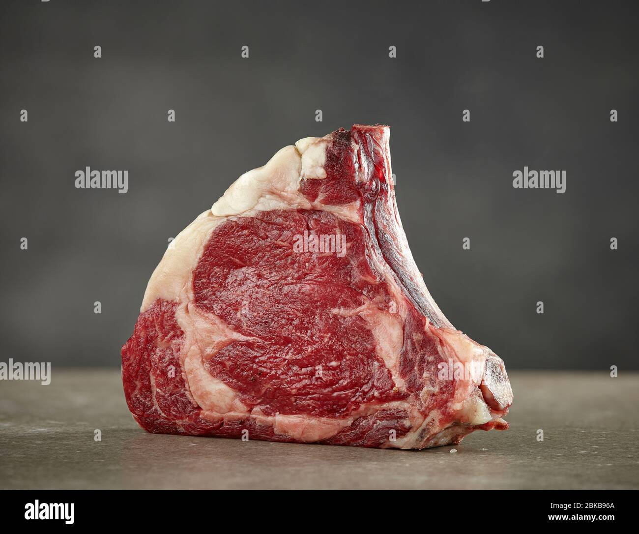 Frisches rohes, trocken gereiftetes Rindfleisch-Steak-Fleisch auf grauem Hintergrund Stockfoto