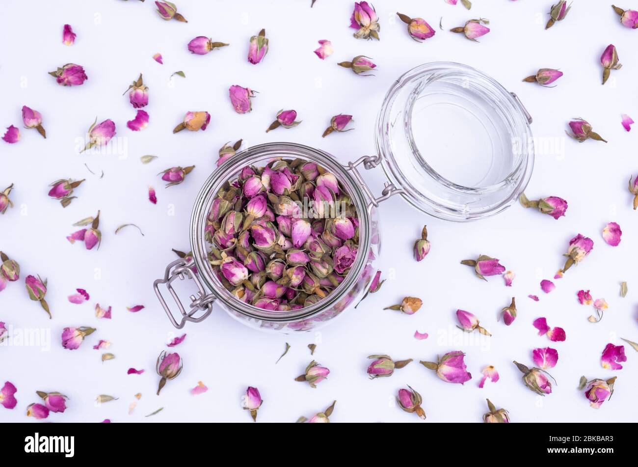 Trockene Rosenknospen für Tee auf weißem Hintergrund. Stockfoto