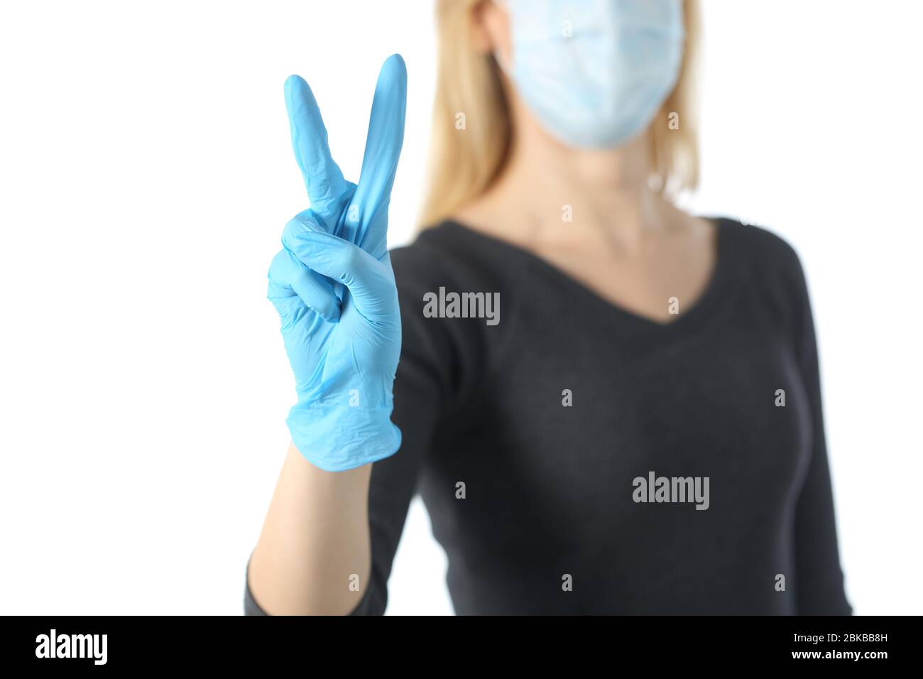 Nahaufnahme von Mädchen Hand Gesturing Sieg Vermeidung covid-19 mit Maske und Handschuhe isoliert auf weißem Hintergrund Stockfoto