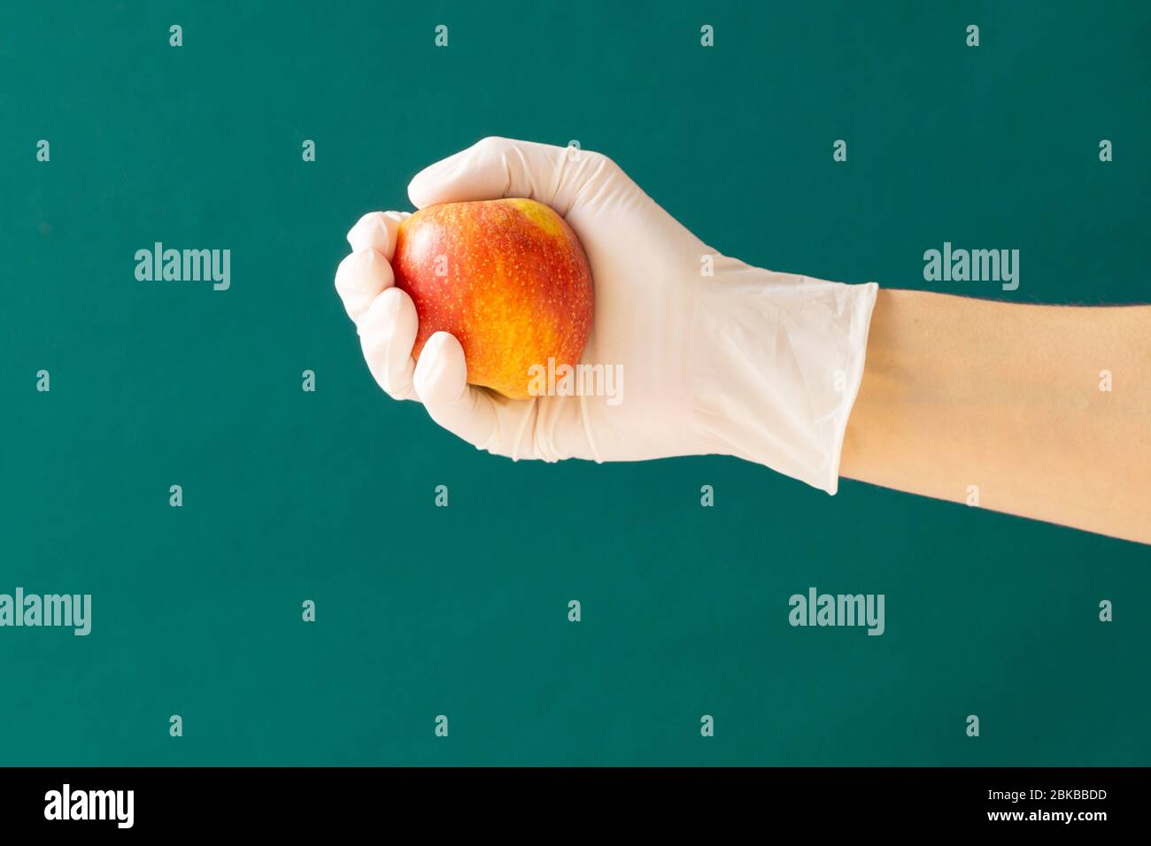 Gummi Handschuher hält einen Apfel. Konzept: Coronavirus. Kopierbereich. Stockfoto