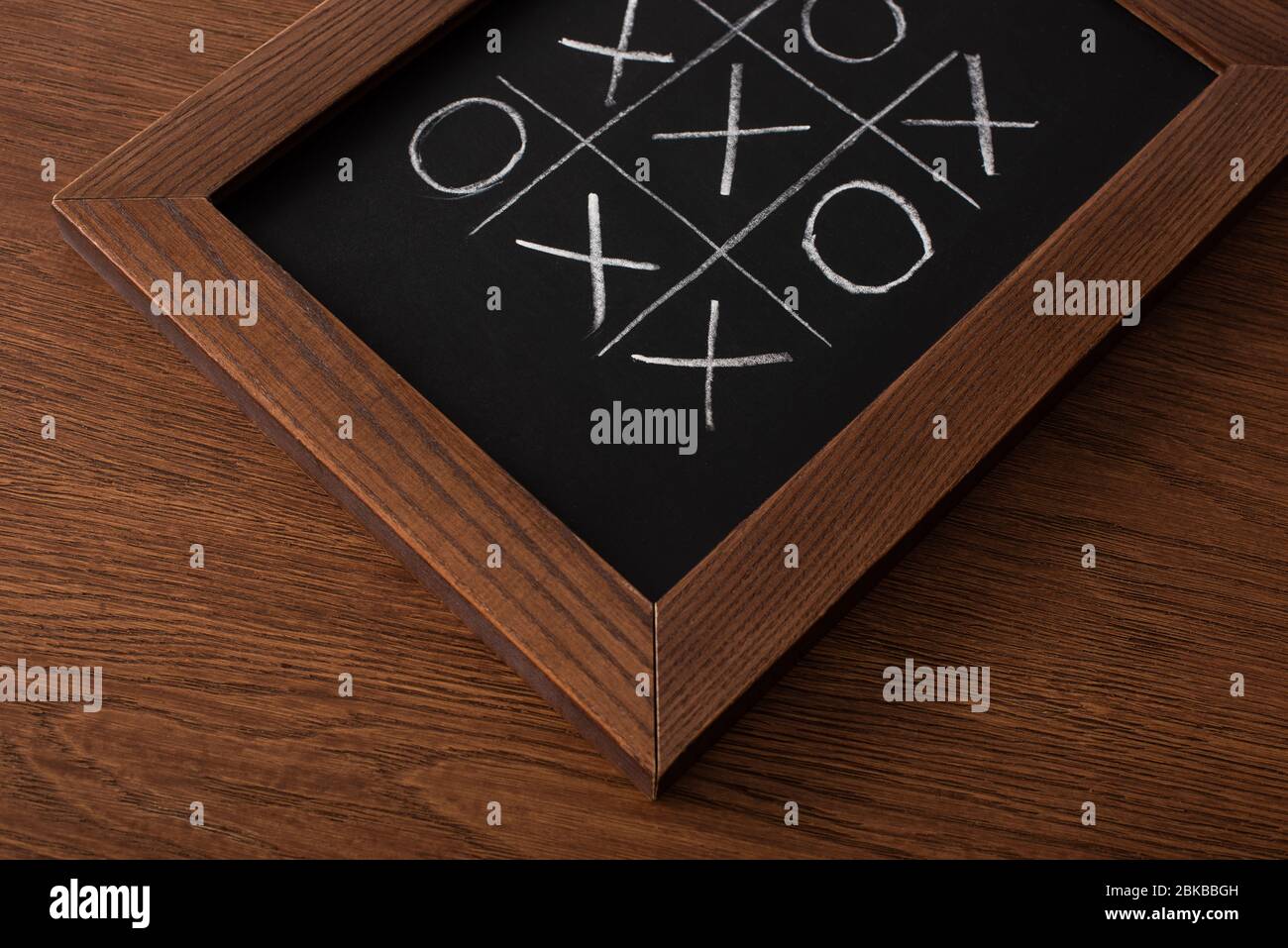 tic tac Zehen Spiel auf Tafel mit Kreide Gitter, Naughts und Kreuze auf Holzfläche Stockfoto