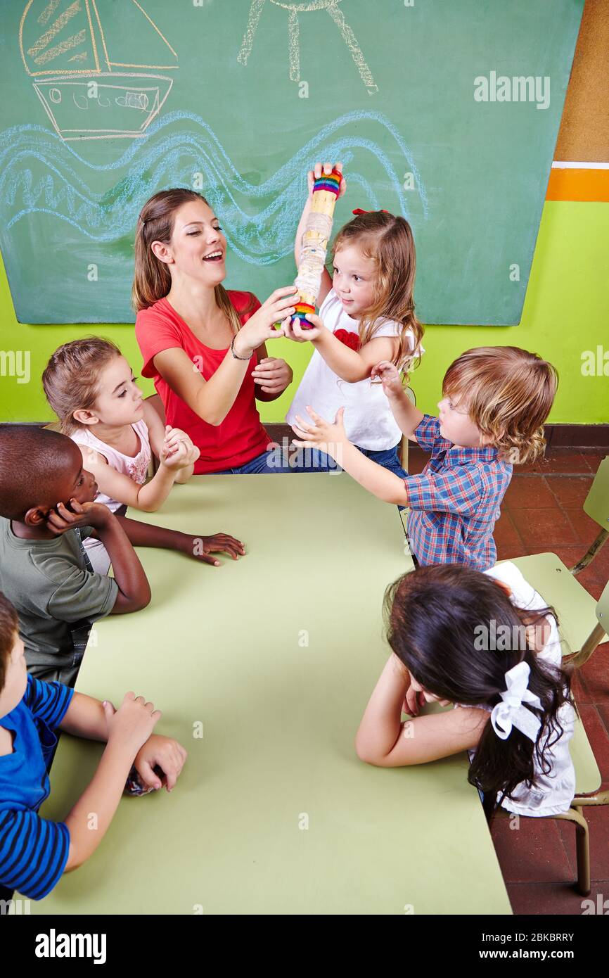 Kinder und Erzieher spielen im Kindergarten mit Regenmachern für die frühe musikalische Bildung Stockfoto