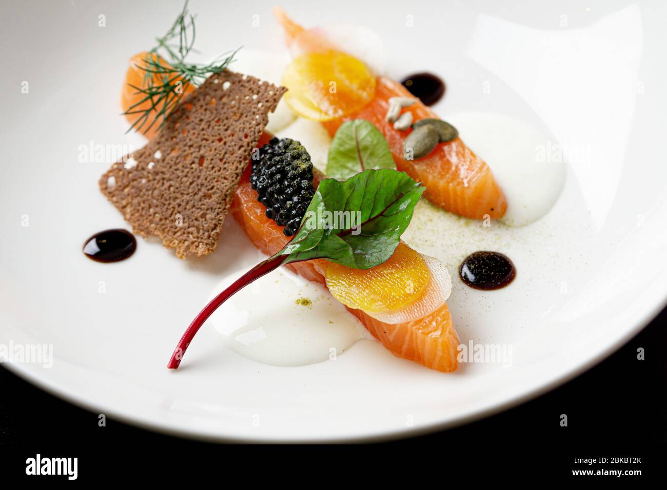 Lachs Vorspeise mit schwarzem Kaviar, Rettichscheiben, Balsamico-Sauce. Stockfoto