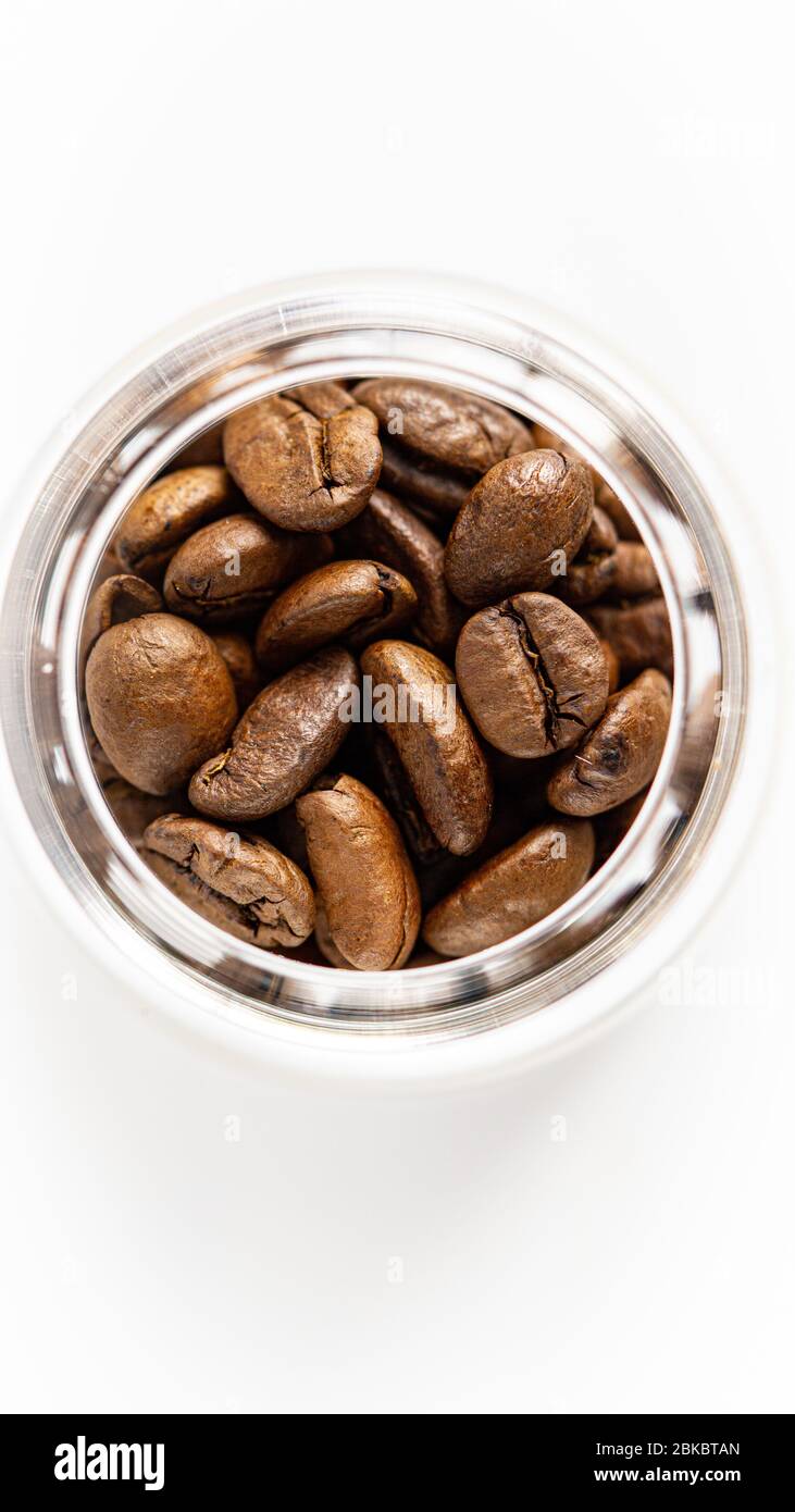 Kaffeebohnen in einem Glas. Nahaufnahme, isoliert, weißer Hintergrund. Stockfoto