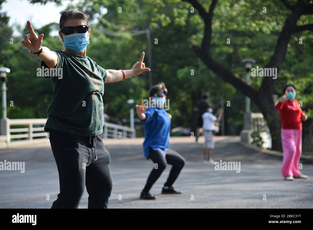 Man sieht, wie man Tai Chi Chuan tut, während man Gesichtsmasken trägt, als Vorsichtsmaßnahme während der teilweisen Aufhebung der Coronavirus-Sperre.nach einem Monat Thailand-Sperre wegen der Covid-19-Krise. Die thailändische Regierung erlaubte es, dass Friseurläden, Parks, Restaurants und Märkte am 3. Mai 2020 wieder eröffnet wurden. Durch Befolgung der Bedingungen der sozialen Distanzierung und Tragen einer Schutzmaske. Stockfoto