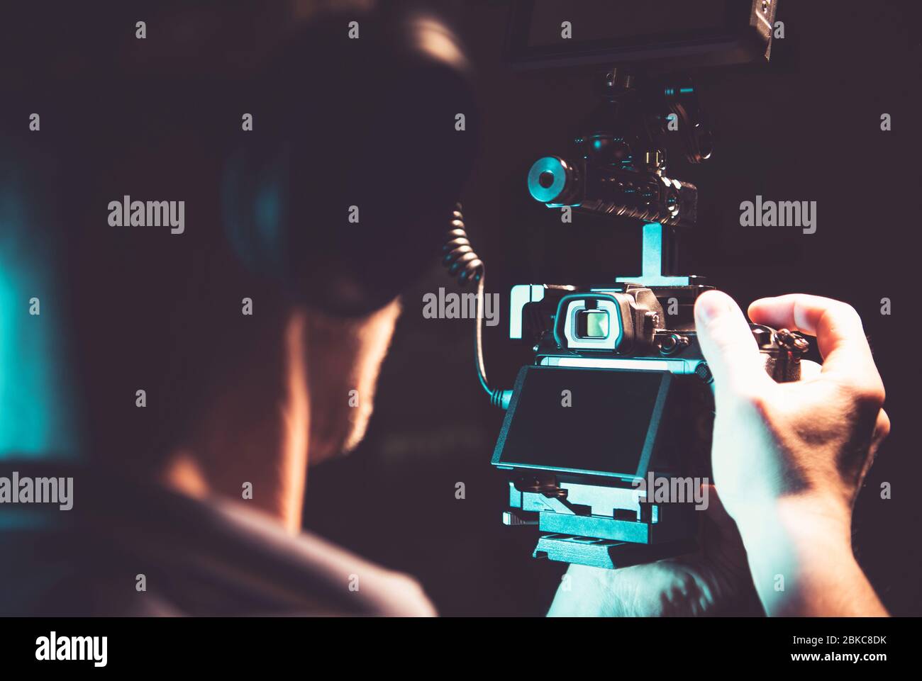 Kaukasische Männer in seinen 30er Jahren die Aufnahme von Dokumentarfilmaufnahmen Handheld mit professioneller DSLR-Kamera. Thema Videografie und Kinematografie. Stockfoto