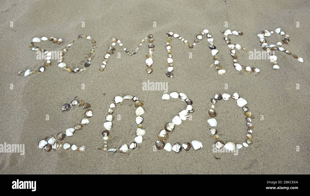 Sommer 2020, Deutsch Wort mit Muscheln am Strand geschrieben. (Sommer 2020) Stockfoto