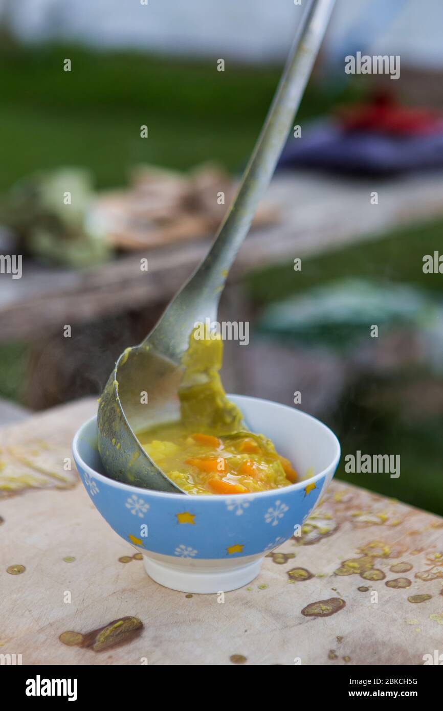 Am Lagerfeuer zubereitete Suppe, die an einem Sommerabend im Wowo's, einem Familiencampingplatz in Sussex, serviert wird Stockfoto