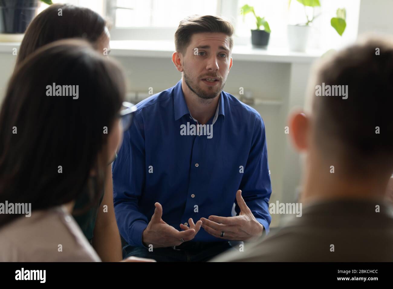 Selbstbewusster, ernster männlicher Coach, Mentor, der Briefing für das Team hält. Stockfoto