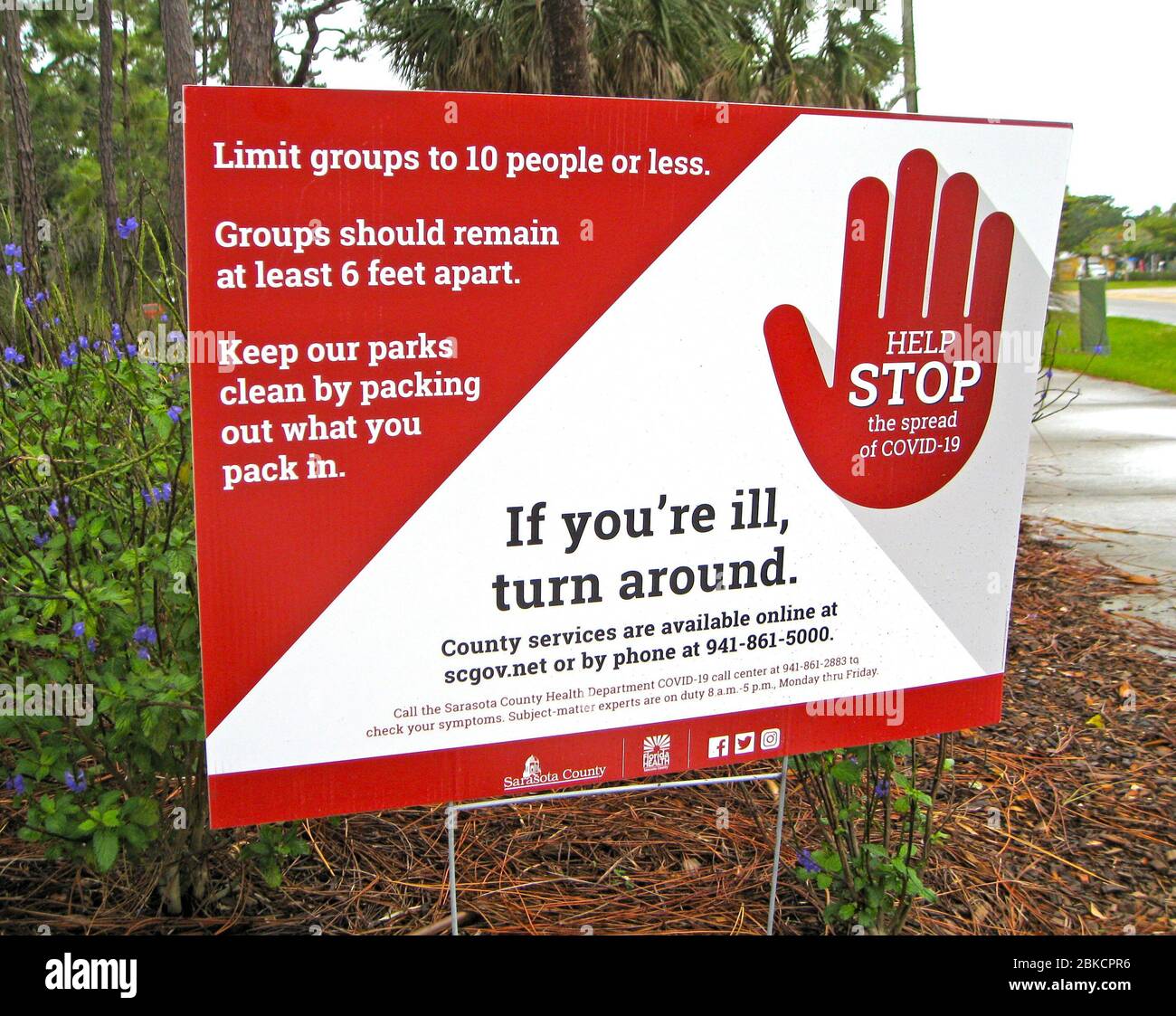 Dieses Schild warnt anfalle kranken Besucher, nicht in einen County Park in Florida, USA, zu gelangen. Ziel ist es, die Ausbreitung von COVID-19, der neuartigen Infektionskrankheit des Coronavirus, die seit 2020 eine weltweite Pandemie auslöste, zu stoppen. Das Schild erinnert auch an lokale Regierungsrichtlinien, die Gruppen auf maximal 10 Personen begrenzen und die Gruppen mindestens 1.8 Meter voneinander entfernt bleiben sollten. Stockfoto