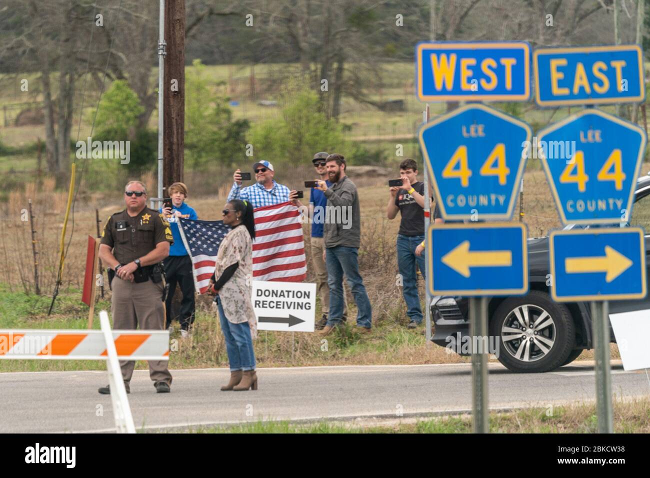 Die Bewohner stehen entlang der Straße, um Präsident Donald J. Trumps Autokolonne am Freitag, 8. März 2019, zu beobachten, wie er die Tornadoschäden an den Nachbarschaften im Lee County, Ala. Untersucht. Präsident Trump und First Lady Melania Trump besuchen Alabama Stockfoto