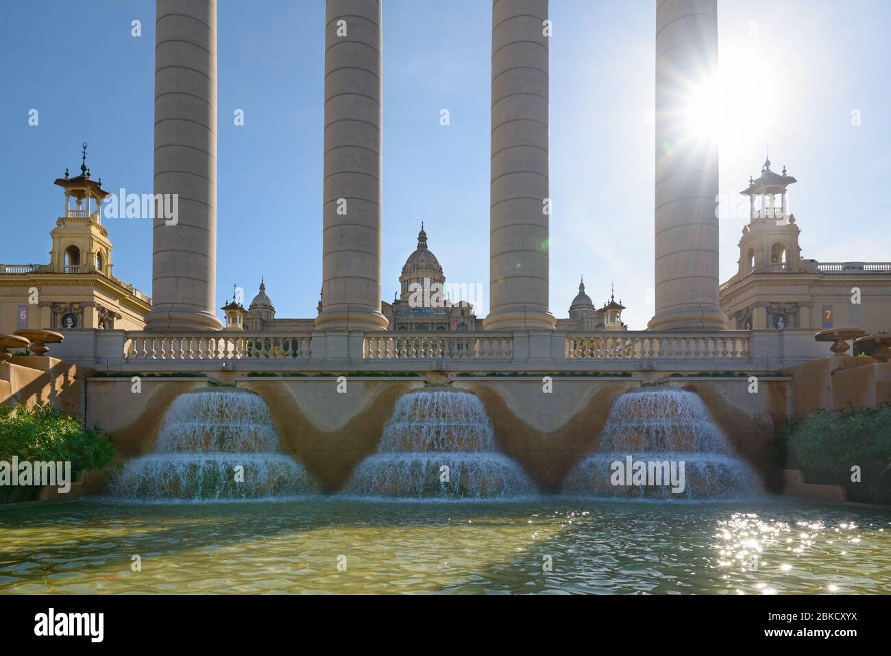 Barcelona, Katalonien/Spanien - die vier Säulen, der Brunnen und der Palast von Montjuic mit Sonne und Strahlen in Barcelona, Katalonien, Spanien. Stockfoto