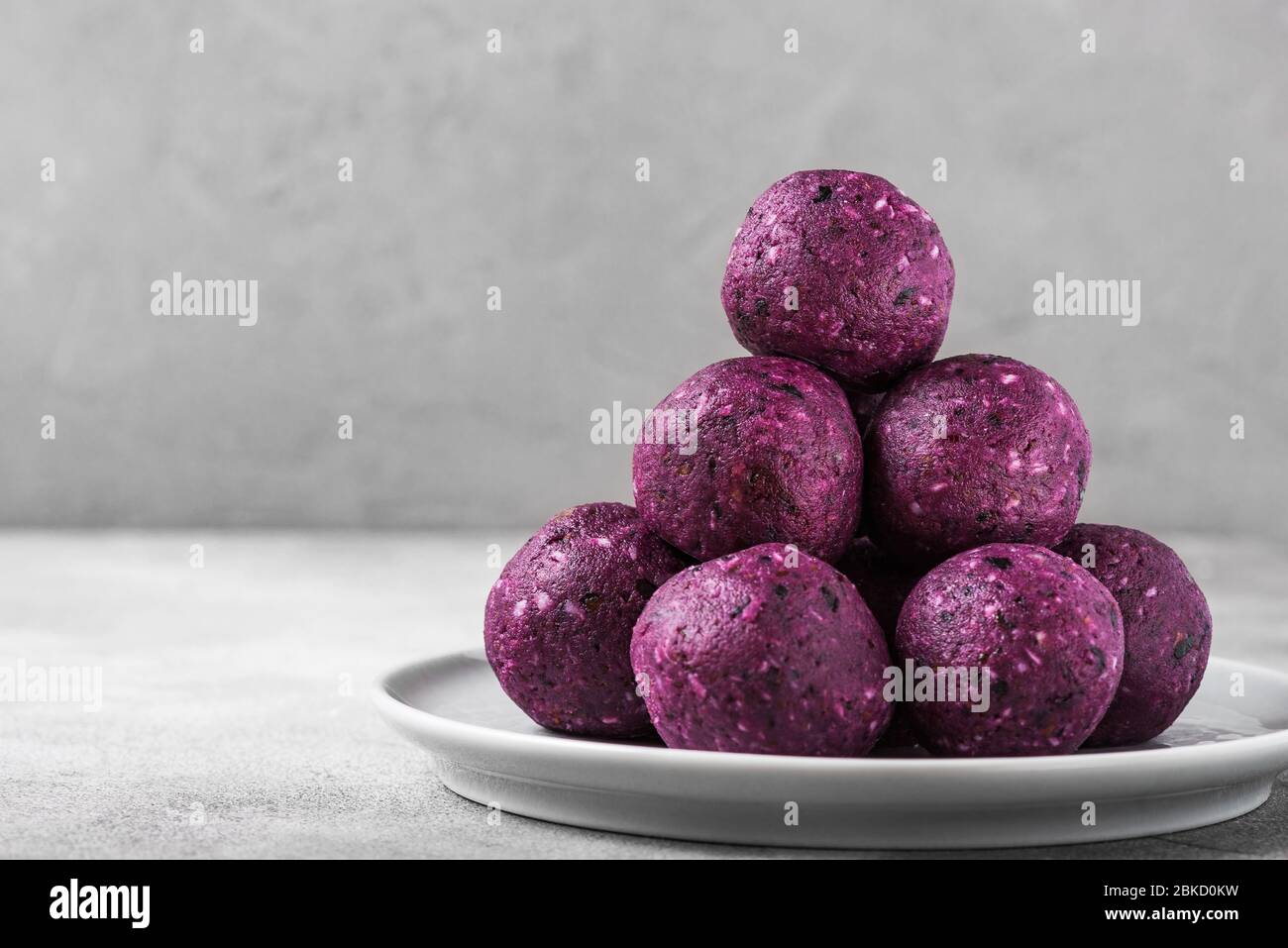 Energy-Kugeln oder Energie Bissen aus Blaubeeren, acai, Datteln und Nüssen. Gesunde vegane Diät-Snacks. Nahaufnahme mit Kopierfläche Stockfoto