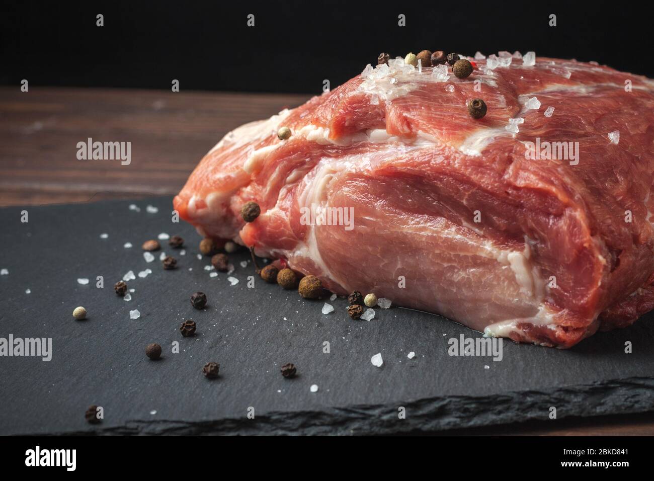 Rohes Schweinefleisch hacken Steak auf einem schwarzen Brett. Schweinehandrikot. Fleisch Stockfoto