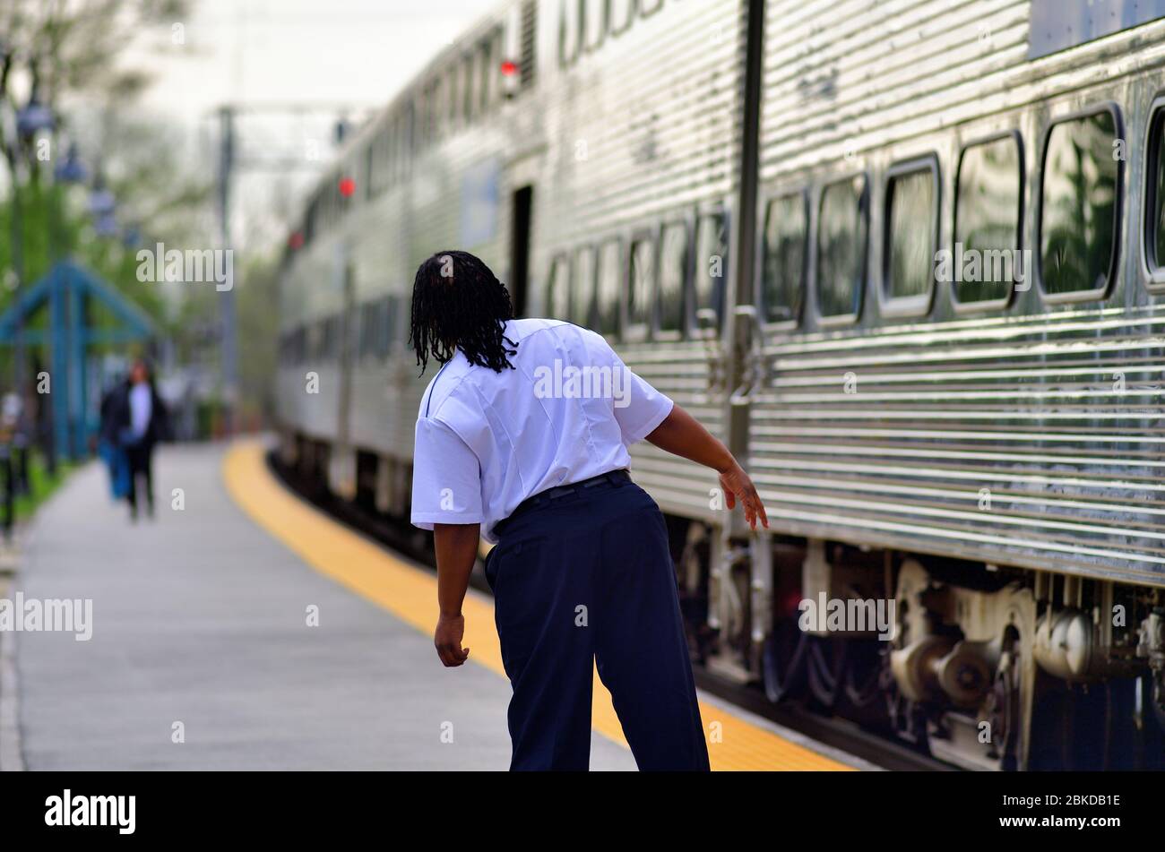 Winfield, Illinois, USA. Ein Schaffner überprüft ihren Zug in einem Pendlerzug, der in der Hauptverkehrszeit von Chicago kommt, bevor er den Bahnhof verlässt. Stockfoto