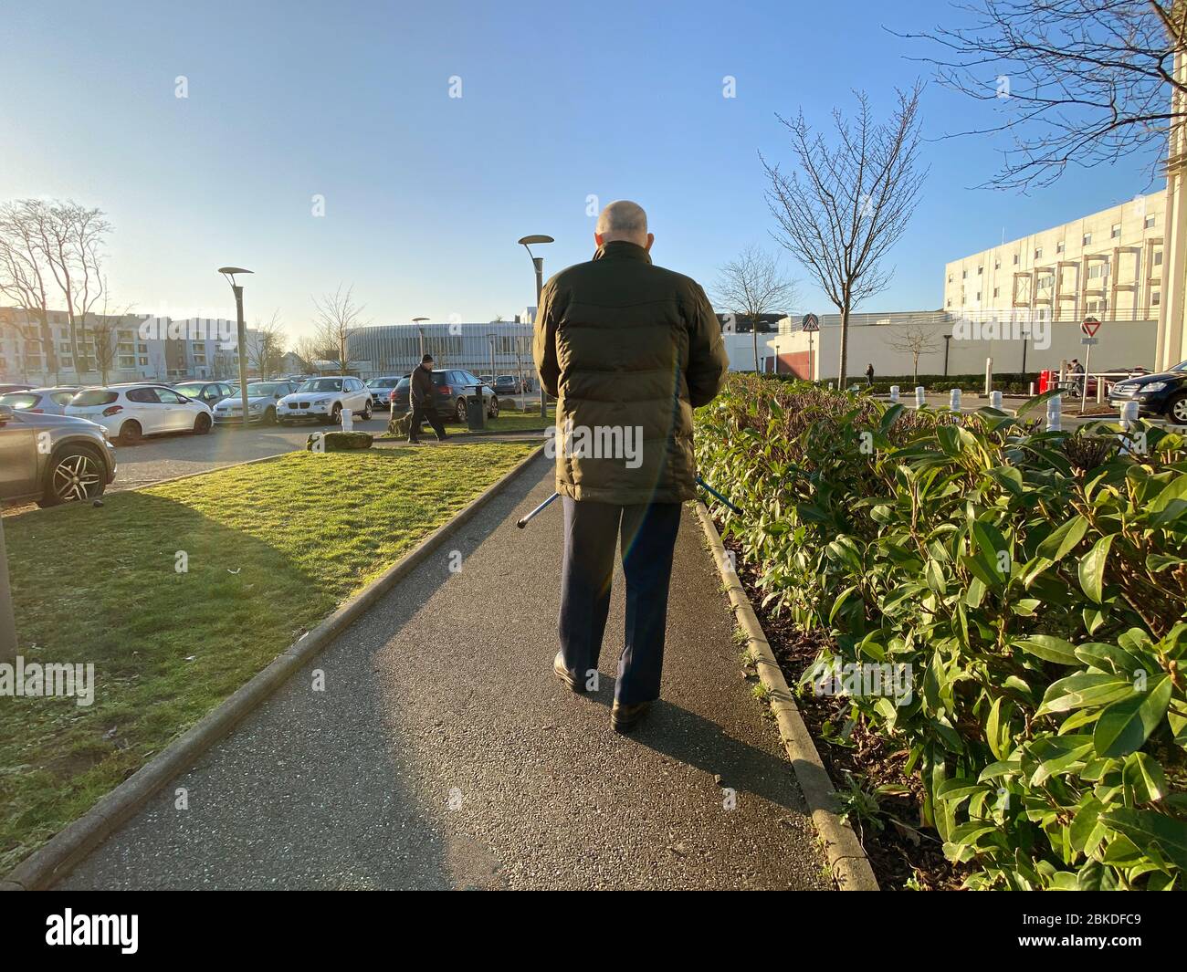 Straßburg, Frankreich - 20. Januar 2020: Rückansicht eines älteren Mannes, der mit Stöcken auf einem großen französischen Parkplatz im Krankenhaus unterwegs ist Stockfoto
