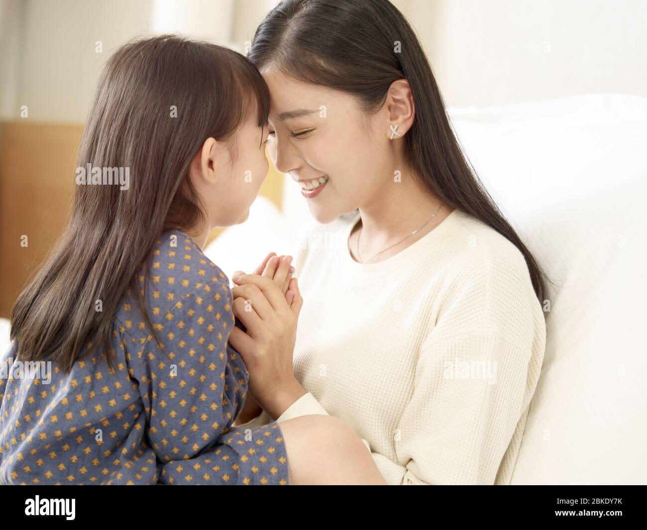Nahaufnahme von liebevollen asiatischen Mutter und nette Tochter im Bett zu Hause sitzen Stockfoto