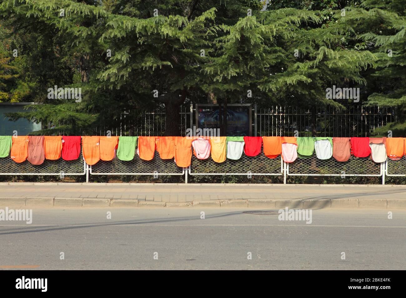 Eine Linie von bunten Wäsche lag auf dem Zaun, um trocken zu sein an einer öffentlichen Straße, Peking, China Stockfoto