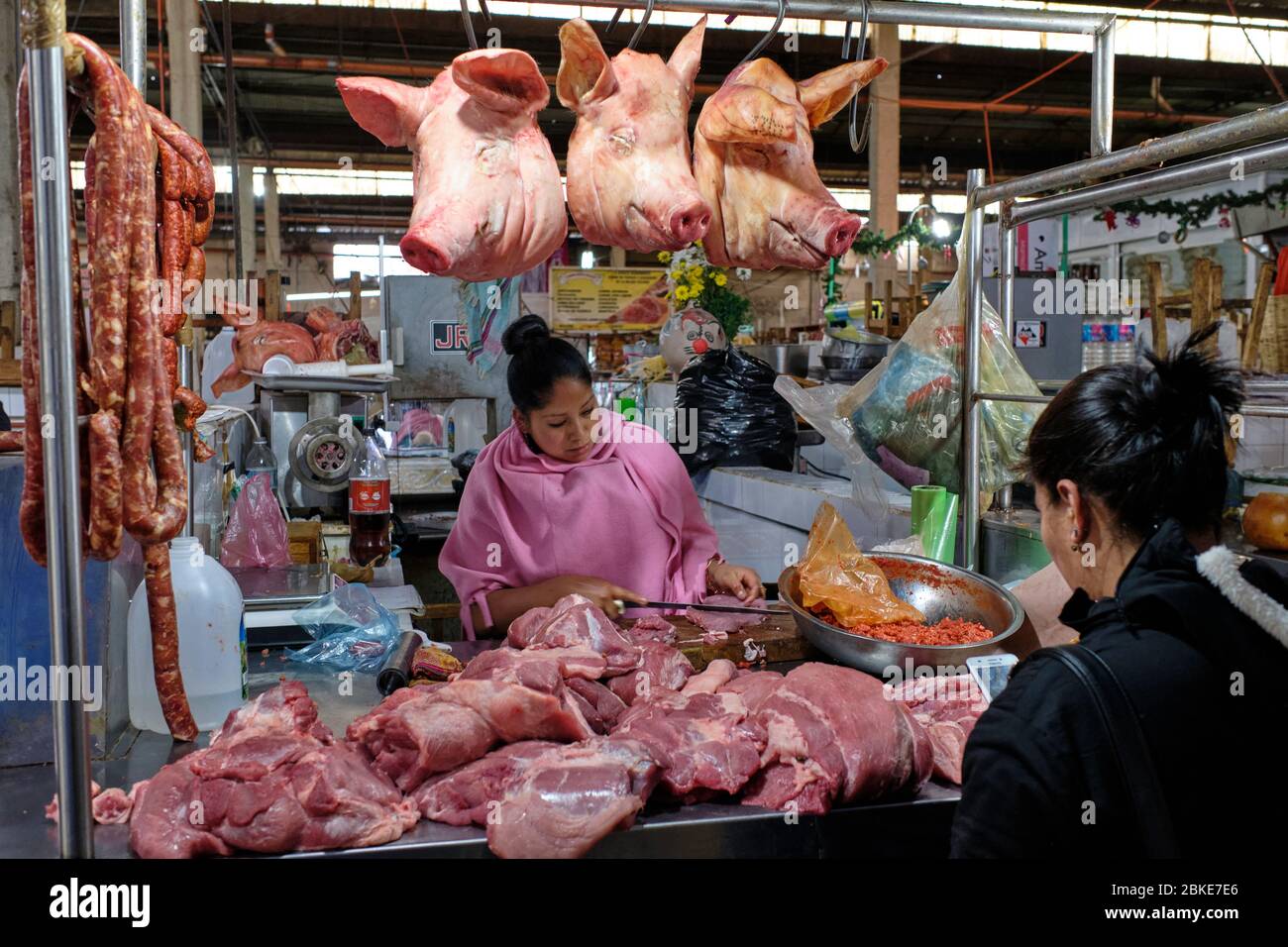 Frau, die Schweinefleisch auf dem Markt von San Cristobal de las Casas verkauft. Stockfoto