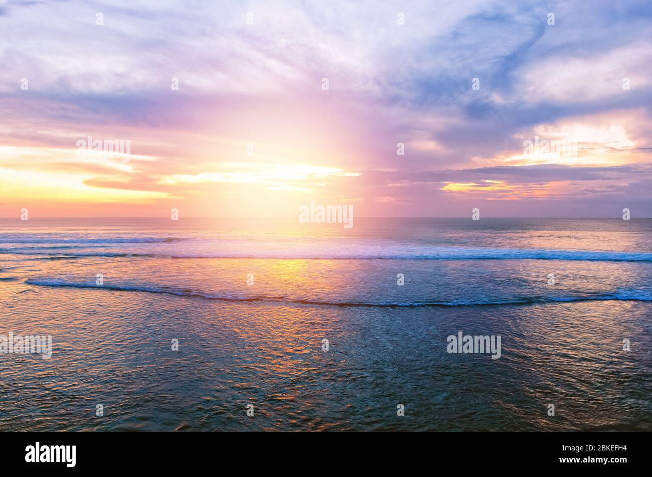 Sonnenuntergang am Meer mit Wasserwellen und kleinen Wellen in den dunklen Farben Stockfoto