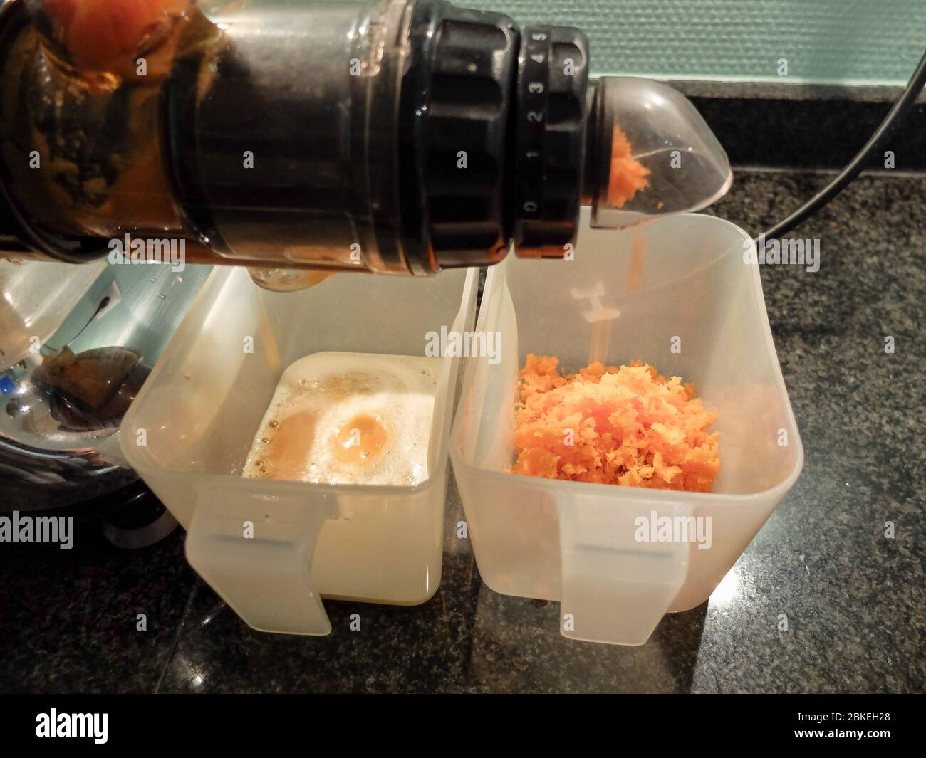 Karottensaftvorbereitung mit dem Saftextraktor Stockfoto
