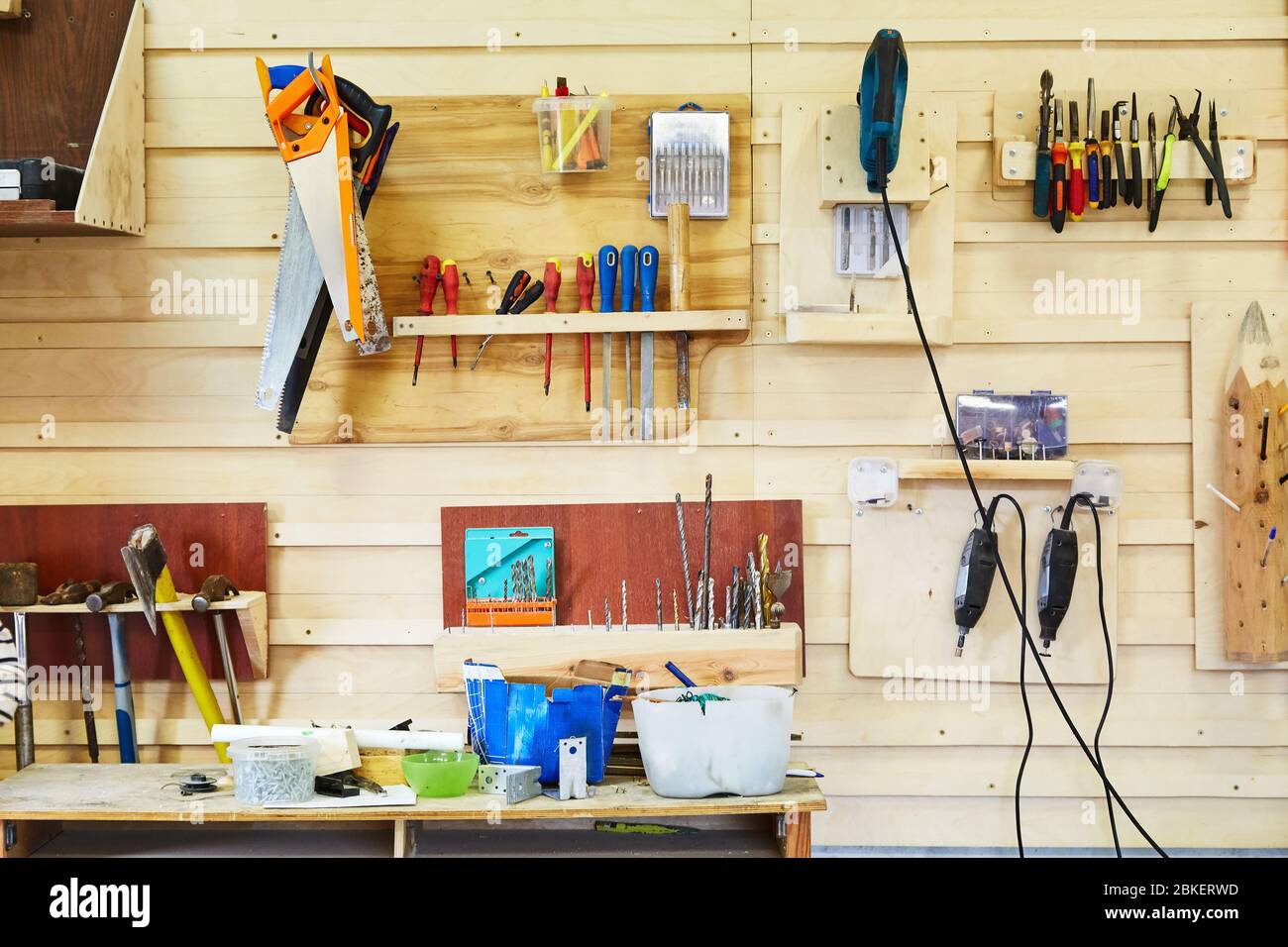 Werkzeuge hängen an der Wand in einer Schreinerei. Sägen, Schraubendreher, Stichsägen, Hämmer, Bohrer, etc. Werkstatt-Szene Stockfoto