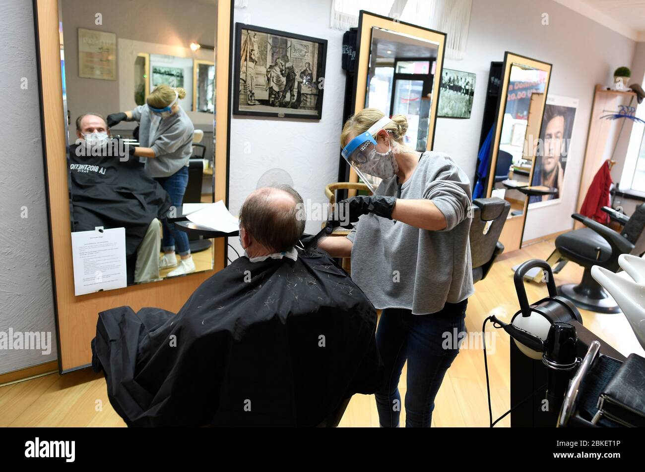 Leverkusen, Deutschland. Mai 2020. Ein Friseur im Salon Norbert Migge schneidet einem Kunden die Haare. Ab dem 4. Mai 2020 können Friseure den Betrieb unter strengen Hygiene- und Sicherheitsstandards wieder aufnehmen. Quelle: Roberto Pfeil/dpa/Alamy Live News Stockfoto