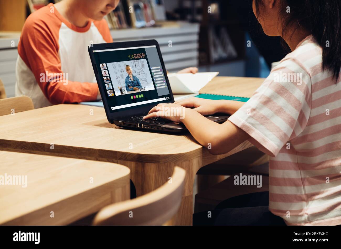 Asiatische Schüler Videokonferenz mit Lehrer und Freunde mit E-Learning-App auf Laptop-Computer zu Hause.Frau auf Teppich liegend.New normales Lernen Stockfoto