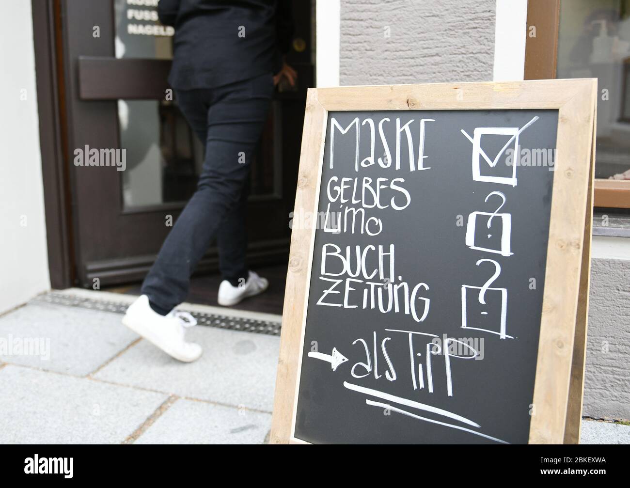 Oberammergau, Deutschland. Mai 2020. Vor dem Eingang eines Friseurs steht ein lustiges Schild mit einem Häkchen bei Maske. Am 19.3.2020 wurden die Oberammergauer Passionsspiele wegen der Verbreitung des Coronavirus abgesagt. Seitdem mussten die Künstler auf einen Besuch beim Friseur warten. Kredit: Angelika Warmuth/dpa/Alamy Live News Stockfoto