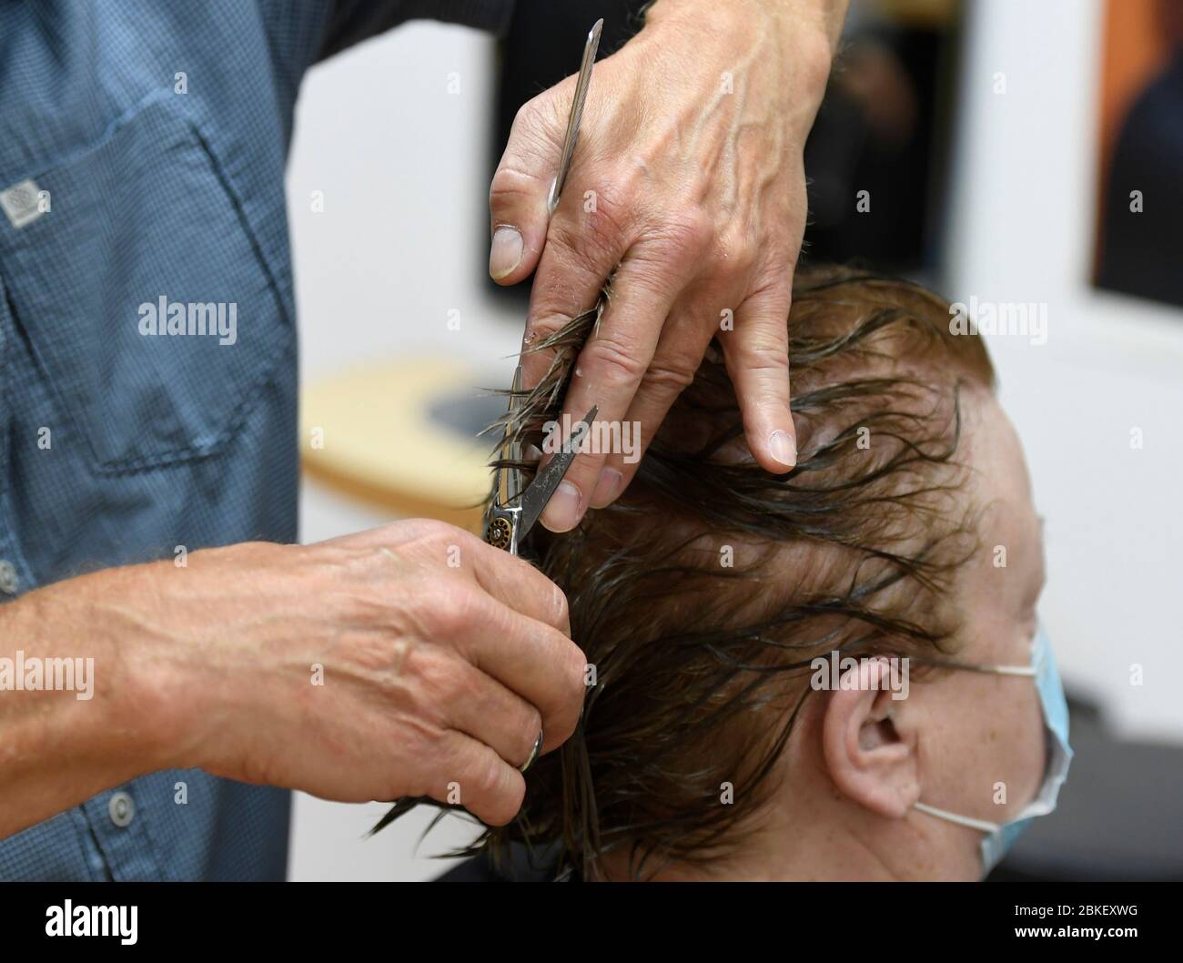 Leverkusen, Deutschland. Mai 2020. Meister Friseur Norbert Migge schneidet einem Kunden in seinem Salon die Haare. Ab dem 4. Mai 2020 können Friseure den Betrieb unter strengen Hygiene- und Sicherheitsstandards wieder aufnehmen. Quelle: Roberto Pfeil/dpa/Alamy Live News Stockfoto