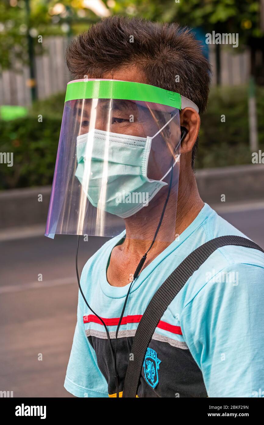 Mann mit Gesichtsschutz und Gesichtsmaske während der Covid 19 Epidemie, Bangkok, Thailand Stockfoto