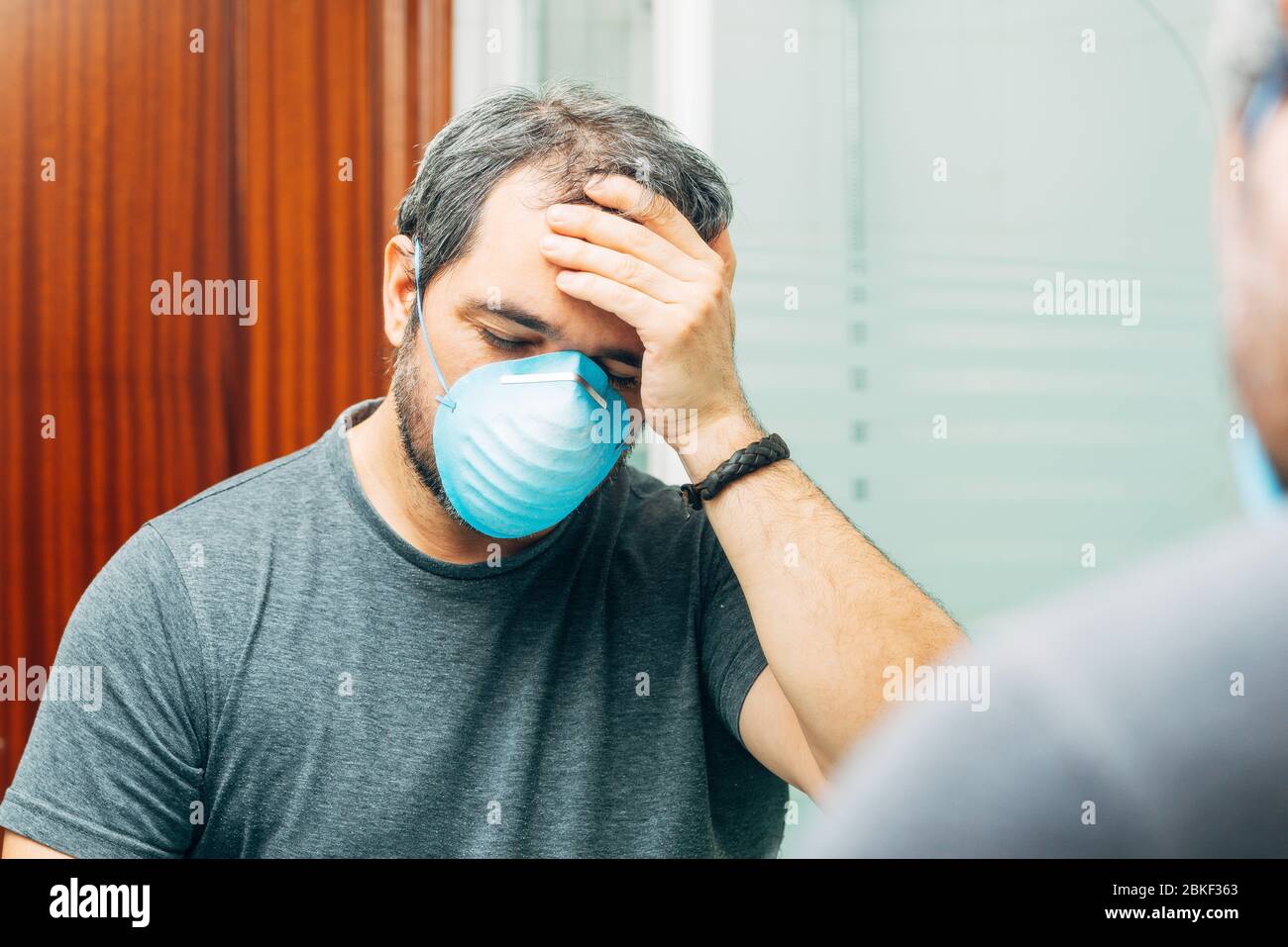 Kranker Mann, der Schweiß abwischt. Coronavirus-Konzept Stockfoto
