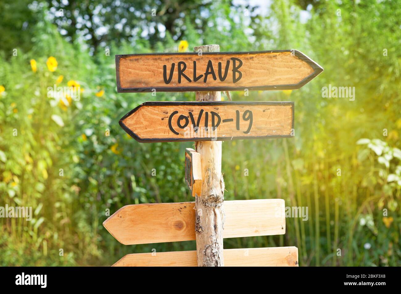 Holzschild mit den Worten Urlaub und Covid-19 (Urlaub, Covid-19) Stockfoto