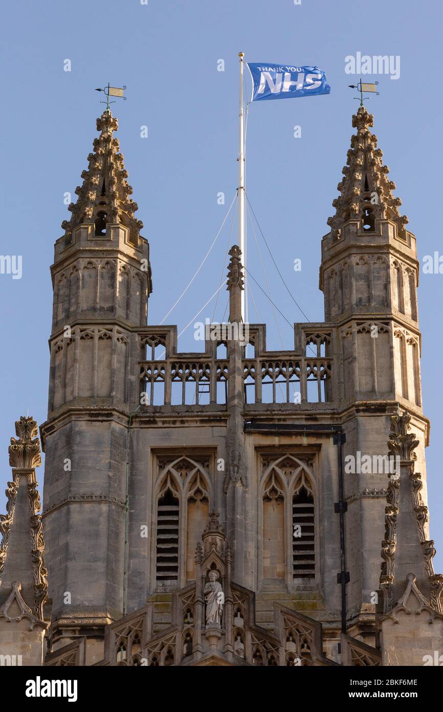 BATH, Großbritannien - 20. APRIL 2020: 'DANKE NHS' Flagge fliegt auf Bath Abbey als Hommage an die Arbeit des National Health Service während der COVID Krise Stockfoto