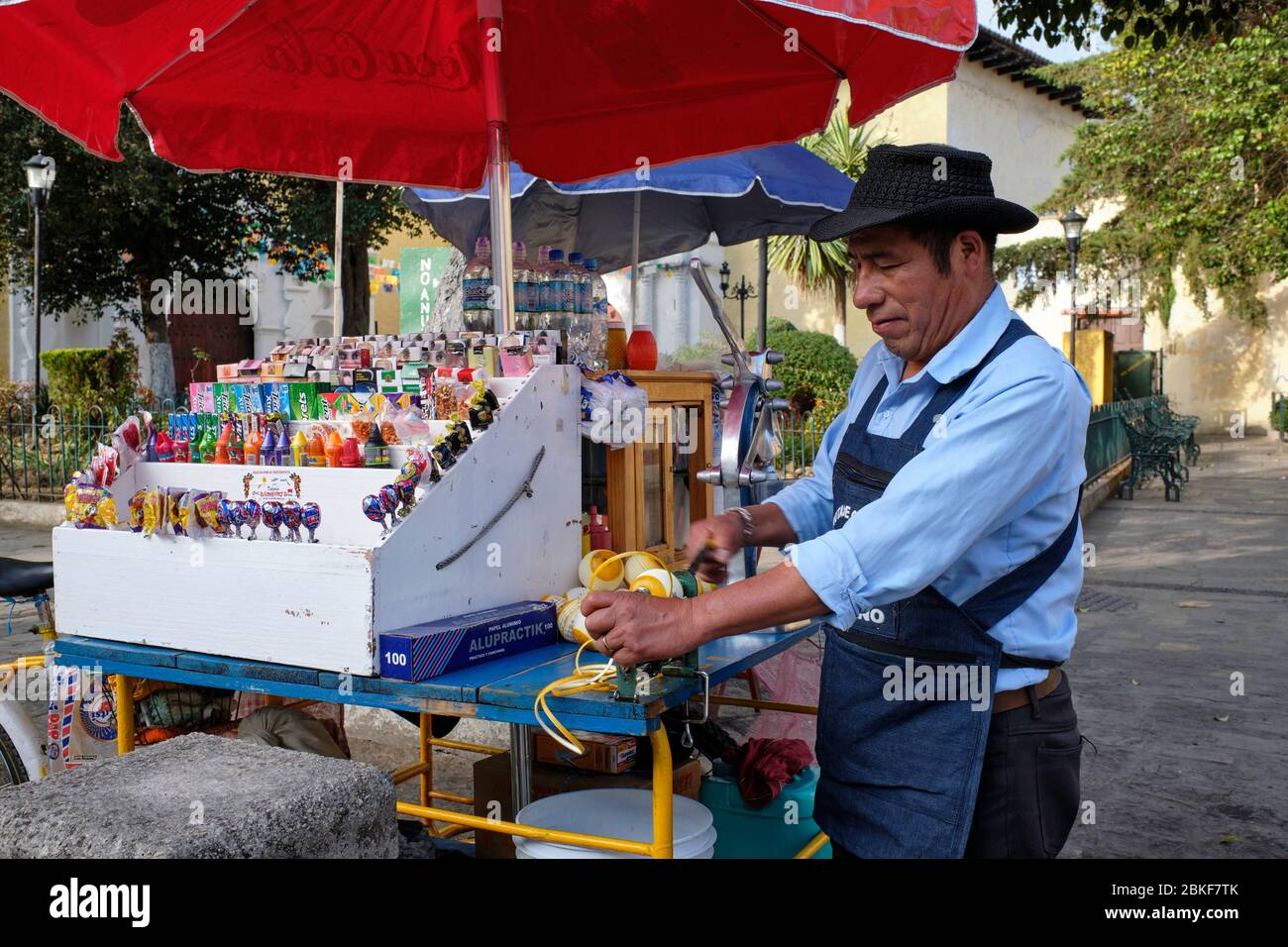 Mann schälte Orangen, um Saft an einem Straßenstand in San Cristobal de las Casas zu machen. Stockfoto