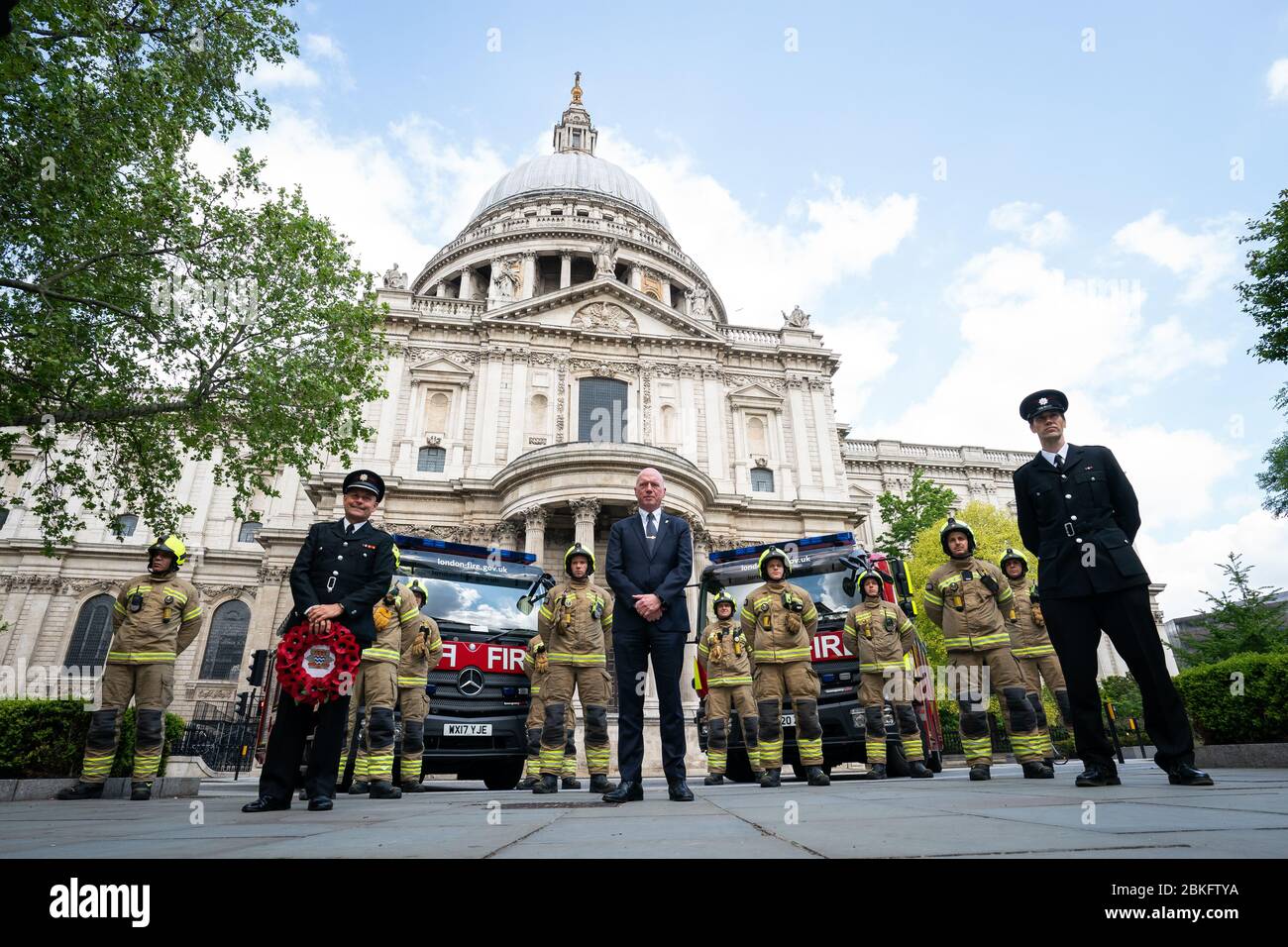 Mitglieder der London Fire Brigade am National Firefighters' Memorial in St. Pauls, London, in Erinnerung an die Feuerwehrleute, die ihr Leben in der Dienstlinie verloren haben. Stockfoto