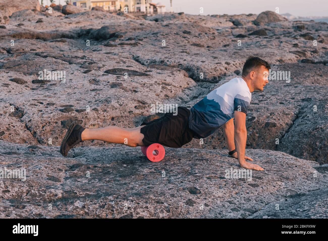 Mann, der selbst Massage des Körpers mit einer Rolle. Faszien-Training Stockfoto