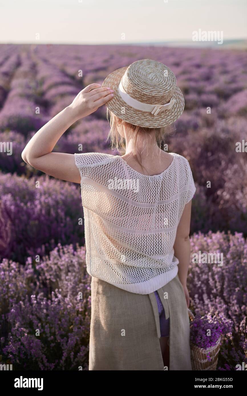 Junges Mädchen in einem Strohhut in den Lavendelfeldern Stockfoto